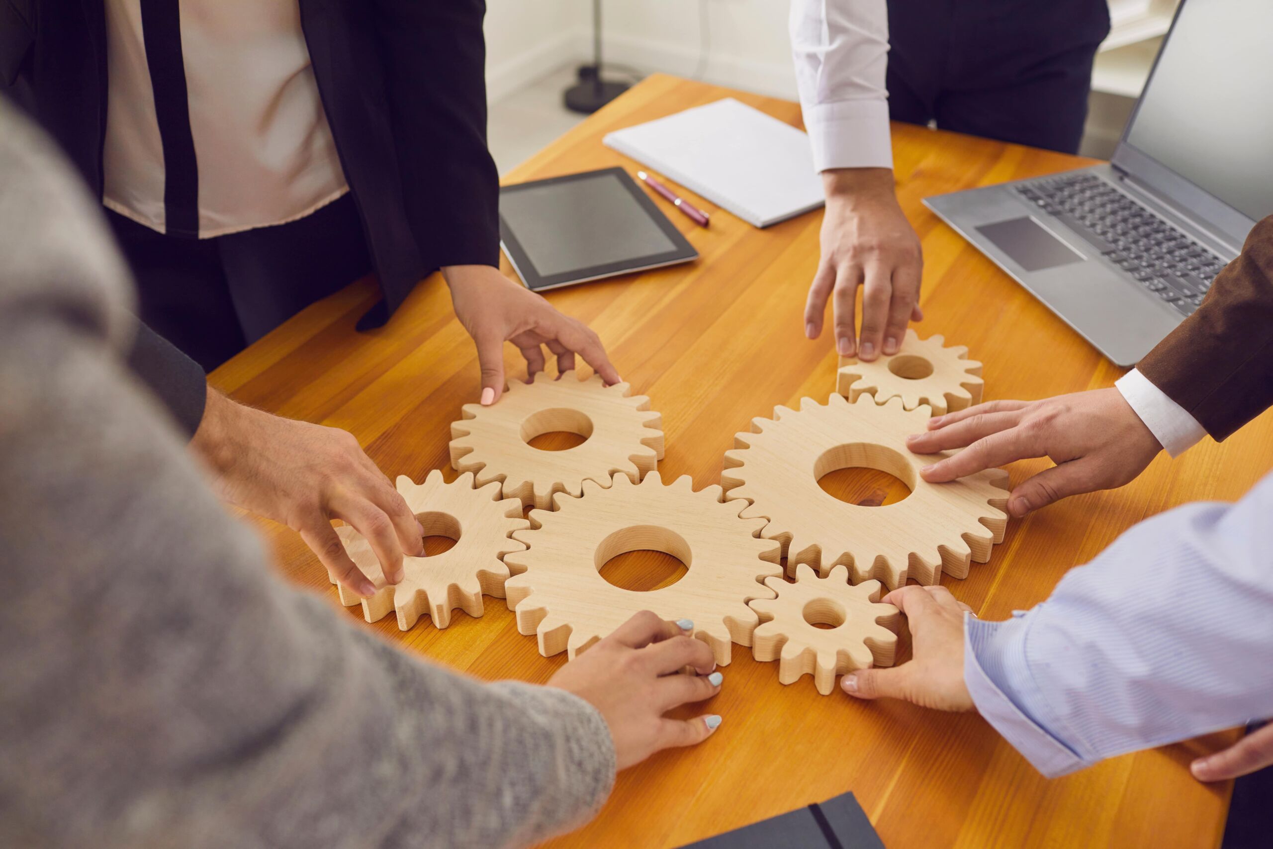 management putting wooden cogs together